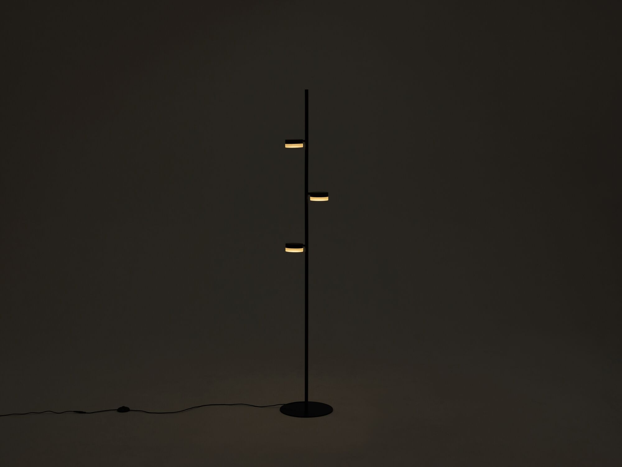 The Row living room floor lamp in a dark room with lights on